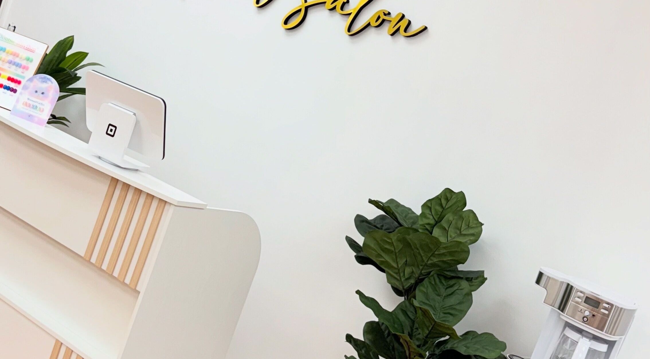 Modern reception at Uxua’s Nail Salon, Clifton, New Jersey, US, featuring sleek decor and indoor plant.
