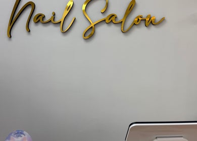 Elegant gold 'Nail Salon' sign at Uxua’s Nail Salon, Clifton, New Jersey, US.