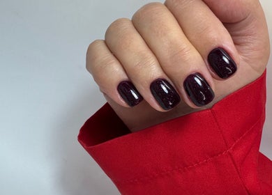 Elegant dark red manicure at DK Nail Aesthetician in Sutton, England, GB, showcasing glossy nail polish.