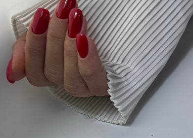 Close-up of polished red nails at DK Nail Aesthetician, Sutton, England, GB. Perfect for chic hand aesthetics.