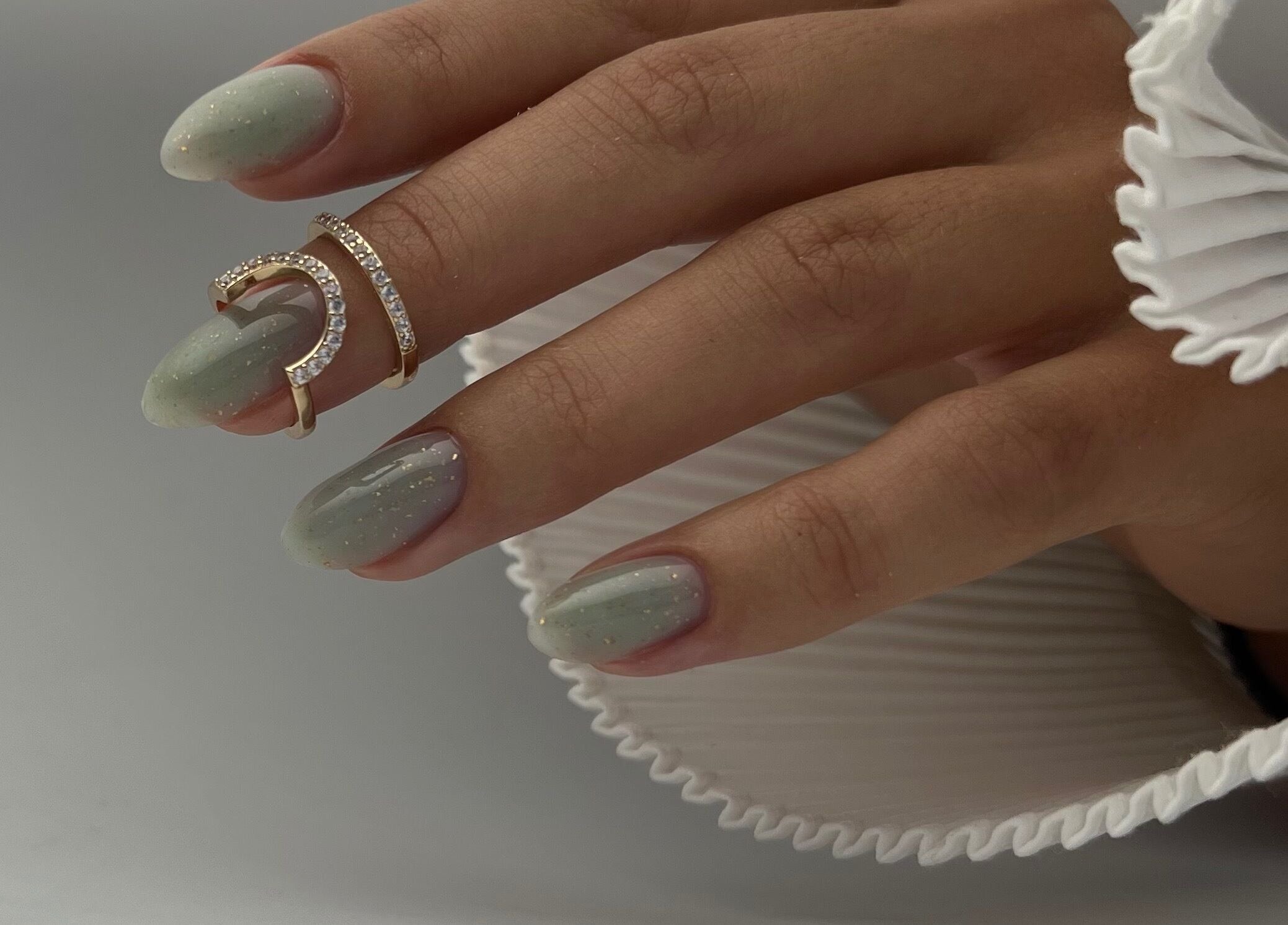 Elegant manicured hand with gold ring at DK Nail Aesthetician, Sutton, England, GB.