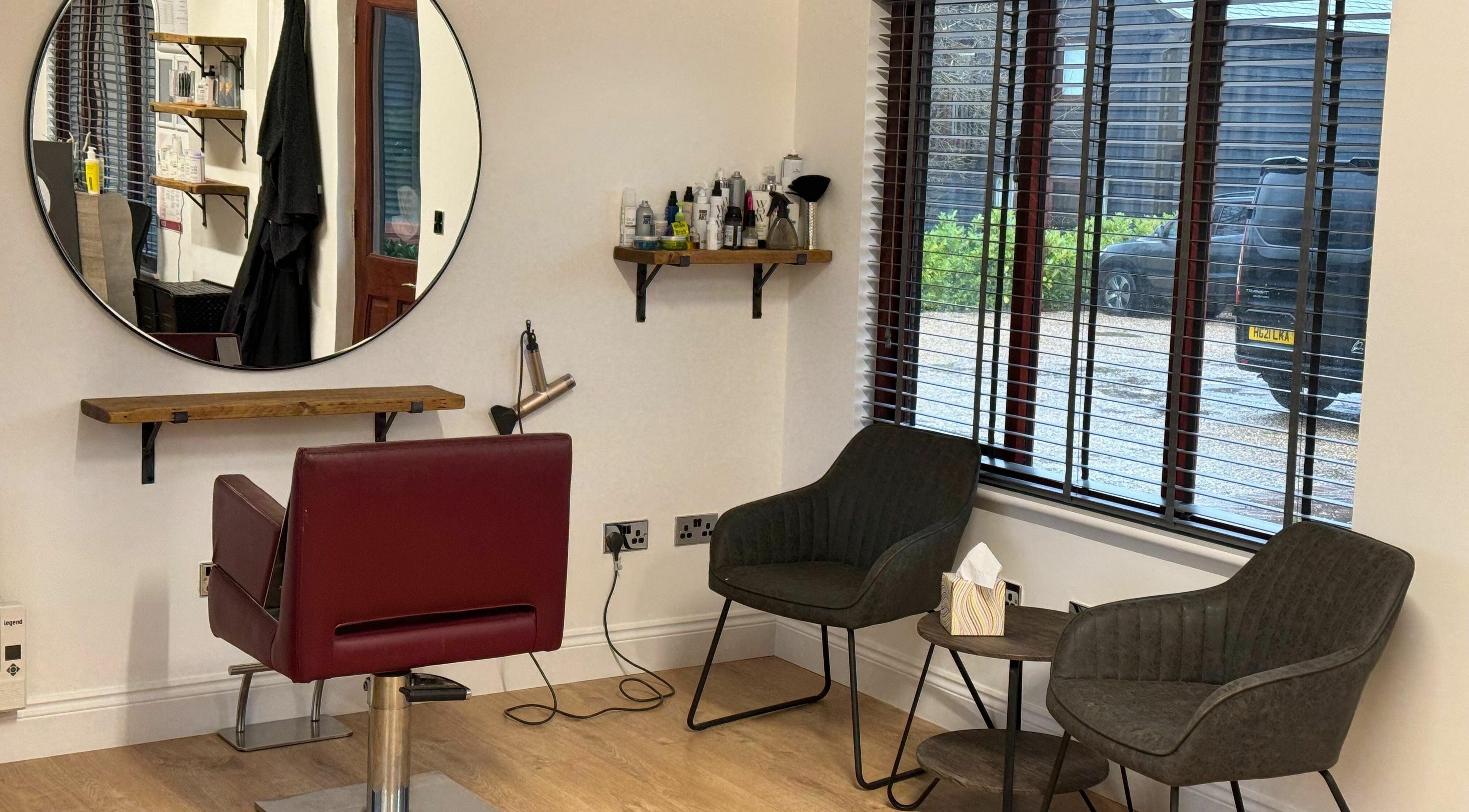 Interior of Kym's Hairstyling, Gaddesden Row, England, featuring elegant styling chair and modern decor.