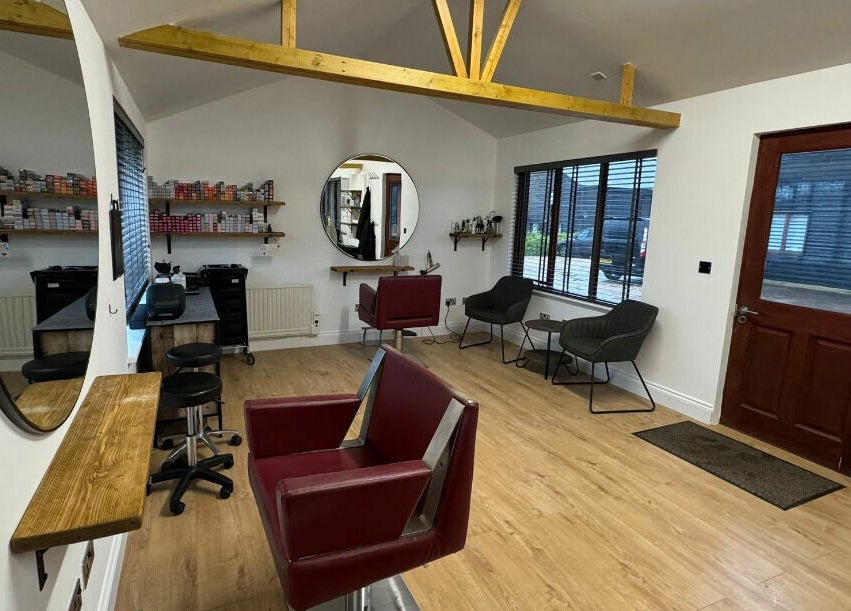 Interior of Kym's Hairstyling in Gaddesden Row, England, featuring stylish salon chairs and decor.