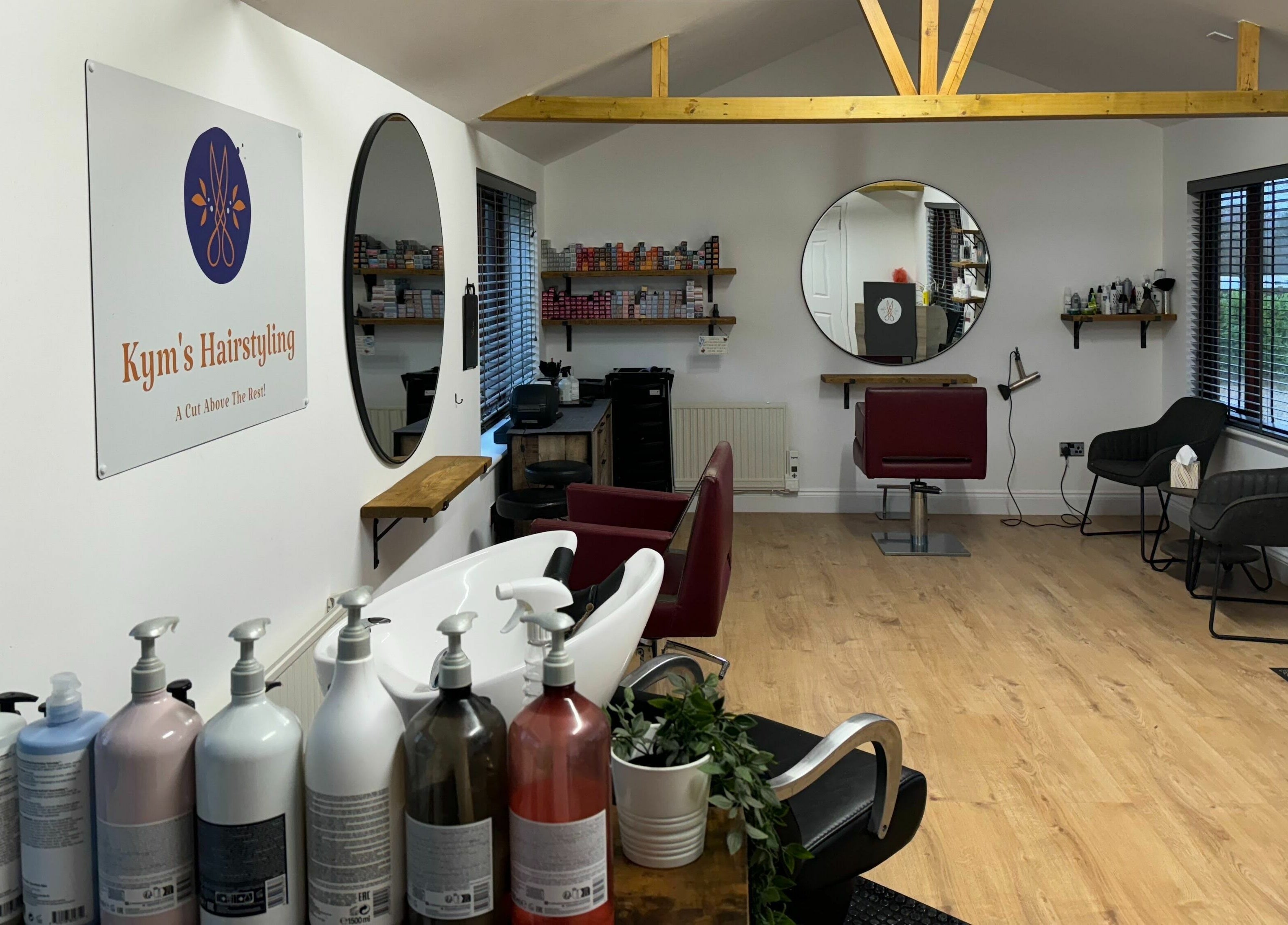 Kym's Hairstyling salon interior on Gaddesden Row, England, GB with mirrors and comfortable seating.