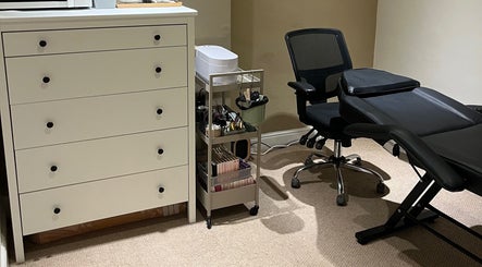 Treatment room at The Hatters Beauty Room, Finedon, England, GB, featuring a massage bed and beauty essentials.