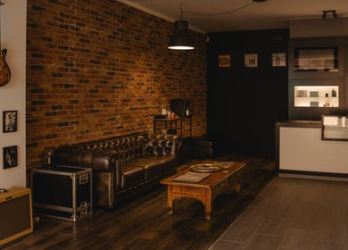 Industriële lounge met leren bank bij REBEL. Piercing Studio, Uden, Noord-brabant, NL.