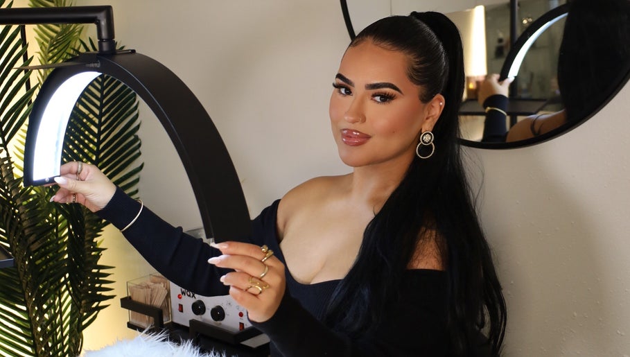 Aesthetician at Esthetics by Carolina Torres, LLC, in Orlando, Florida, US, adjusting a beauty lamp.