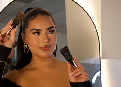 Makeup application at Esthetics by Carolina Torres, LLC in Orlando, Florida, US with woman holding beauty product.