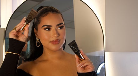 Makeup application at Esthetics by Carolina Torres, LLC in Orlando, Florida, US with woman holding beauty product.