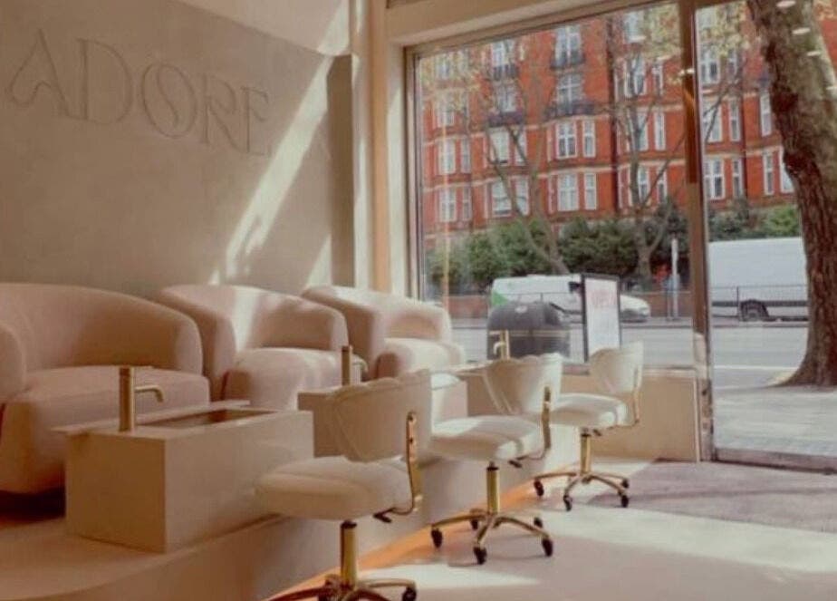 Modern nail salon interior at LUMIÁ NAILS MARYLEBONE, London, England, GB with plush seating and street view.