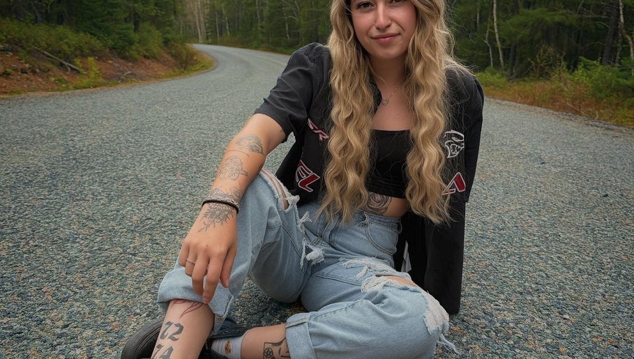 Jeune femme assise sur une route près de Mylène Esthétique, Rouyn-noranda, Québec, CA.