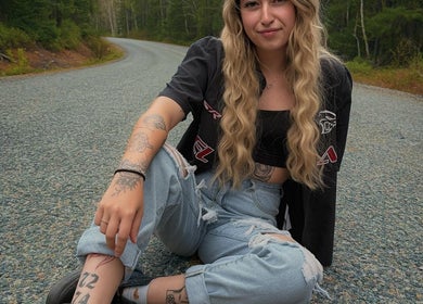 Jeune femme assise sur une route tranquille à Rouyn-noranda, Québec, CA, près de Mylène Esthétique.