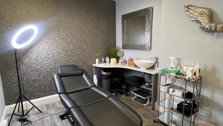 Modern treatment room at Aura Aesthetics, Leeds, England, GB. Equipped with chair, mirror, and skincare products.