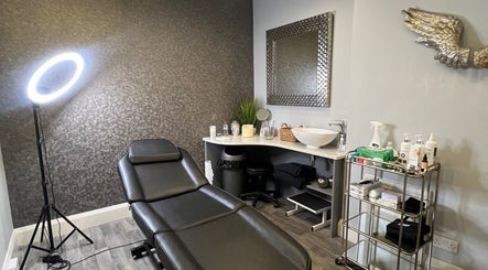 Modern treatment room at Aura Aesthetics, Leeds, England, GB. Equipped with chair, mirror, and skincare products.