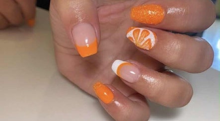 Manucure orange vif chez Mia Esthétique, Rouyn-Noranda, Québec, CA, avec accent pailleté et motif agrume.