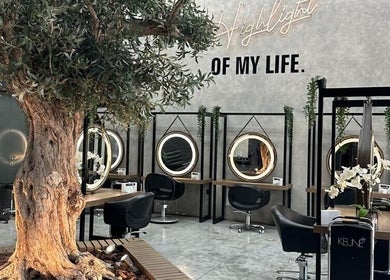 Interior do Brazil Studio Salon em Manama, Manama, BH, com decoração natural e espelhos iluminados.