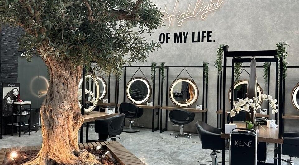 Interior do Brazil Studio Salon em Manama, Manama, BH, com decoração natural e espelhos iluminados.