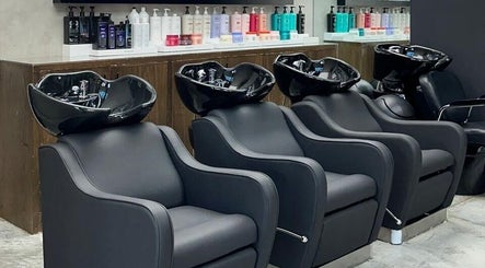 Cadeiras de lavagem no salão Brazil Studio Salon em Manama, BH, com produtos capilares ao fundo.