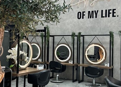 Interior moderno do Brazil Studio Salon em Manama com espelhos circulares iluminados.