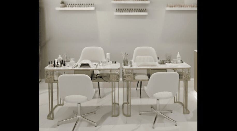 Chic nail salon setup at Beauty Essentials, Edinburgh, Scotland, GB, featuring modern white chairs and manicure tables.