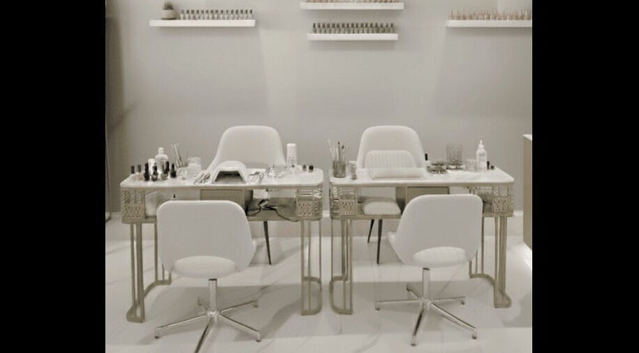 Chic nail salon setup at Beauty Essentials, Edinburgh, Scotland, GB, featuring modern white chairs and manicure tables.