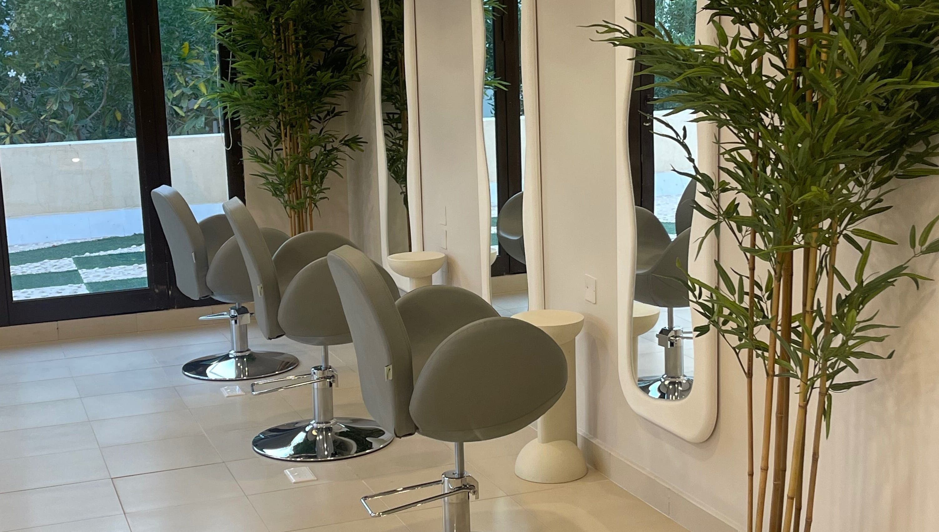 Modern salon chairs and mirrors at Soul By Mays, Riyadh, Riyadh Province, SA adorned with lush greenery.