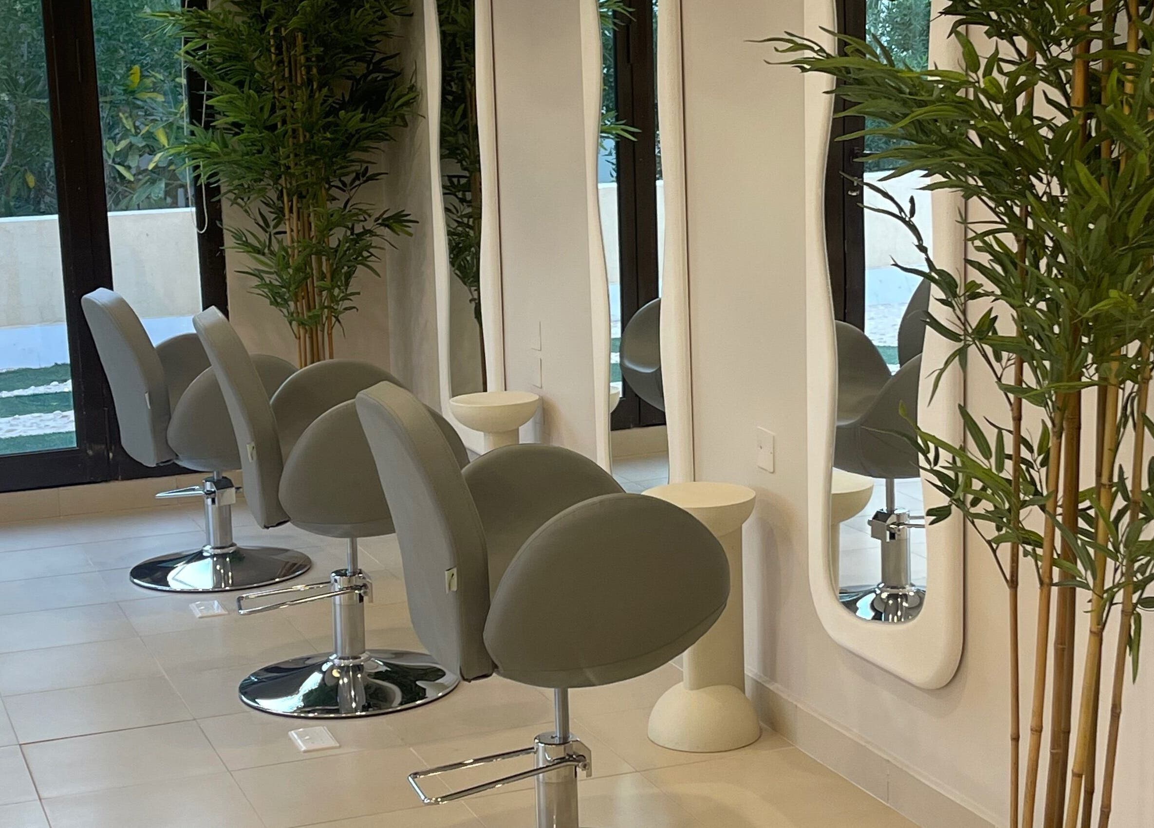 Modern salon chairs and mirrors at Soul By Mays, Riyadh, Riyadh Province, SA adorned with lush greenery.
