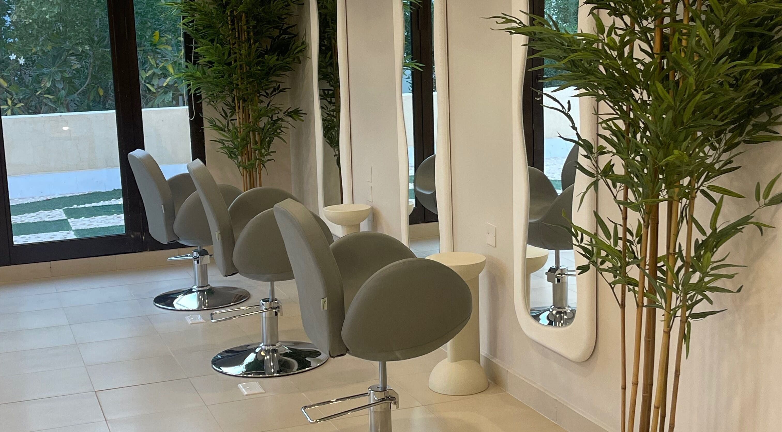 Modern salon chairs and mirrors at Soul By Mays, Riyadh, Riyadh Province, SA adorned with lush greenery.