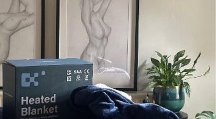 Carly Whitington London wellness center with a heated blanket, artwork, and plant on display.