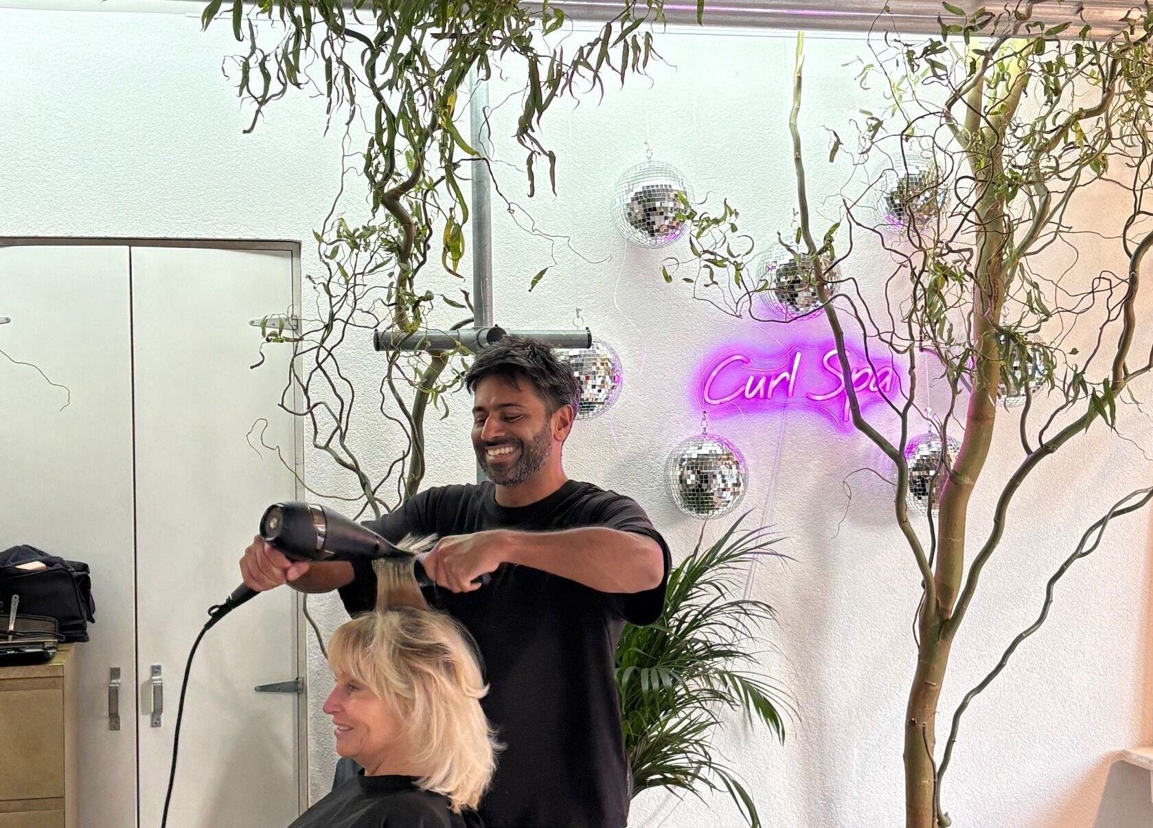 Stylist at Curl Spa Salon Amsterdam blow-drying a client's hair in a chic setting, Amsterdam, Noord-Holland, NL.