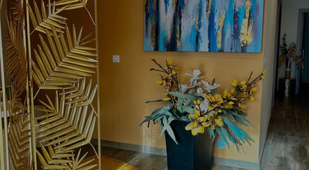 Décoration élégante au L’instant Précieux, Afa, Corse, FR avec tableau abstrait et plantes vibrantes.