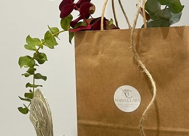 Bolsa de papel de Maria Clara Terapias Manuales by Brasil en Barcelona, Catalunya, ES, adornada con hojas.