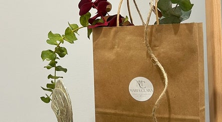 Bolsa de papel de Maria Clara Terapias Manuales by Brasil en Barcelona, Catalunya, ES, adornada con hojas.