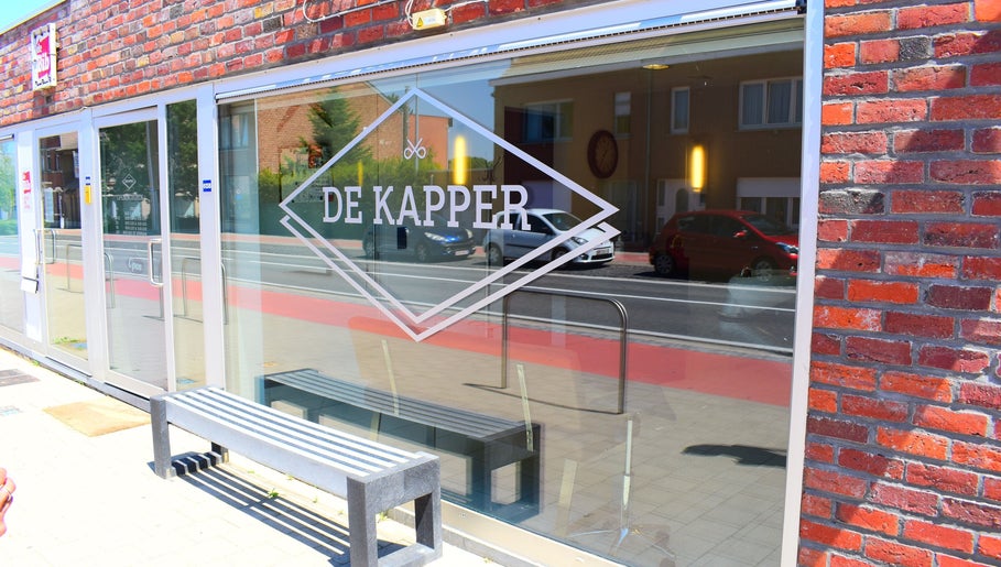 Buitengevel van De Kapper Elewijt met glazen deur in Zemst, Vlaanderen, BE.