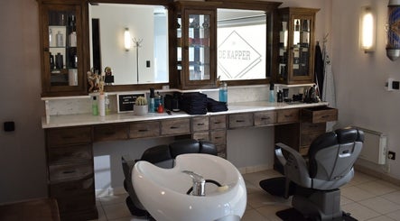 Interieur van De Kapper Elewijt in Zemst, Vlaanderen, BE met moderne kappersstoel en houten meubelen.