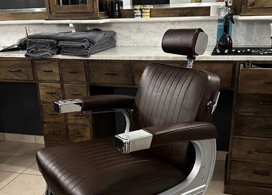 Bruine kapperstoel en houten wand bij De Kapper Elewijt, Zemst, Vlaanderen, BE.