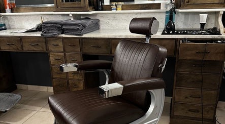 Bruine kapperstoel en houten wand bij De Kapper Elewijt, Zemst, Vlaanderen, BE.