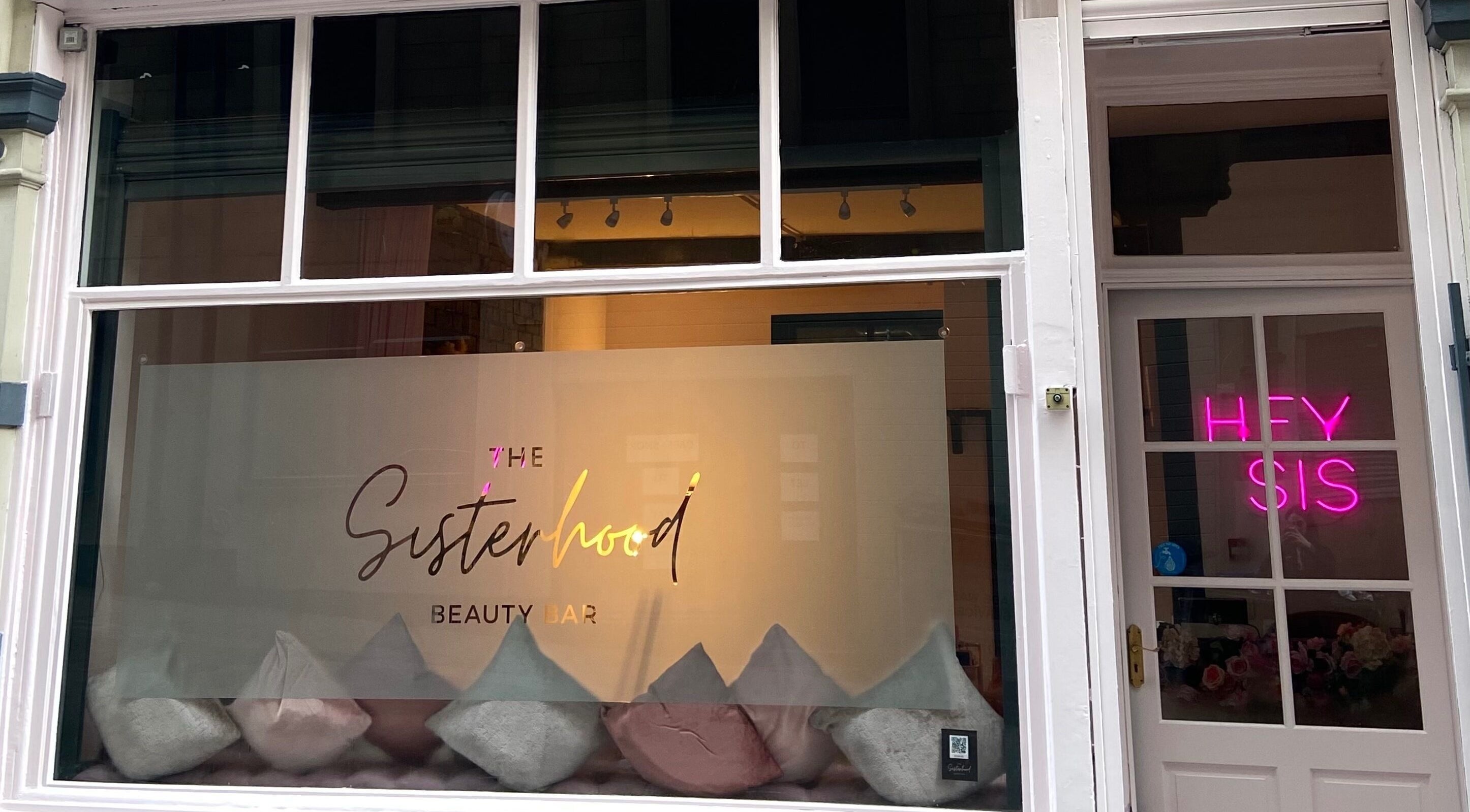 The Sisterhood Beauty Bar storefront in Bradford, England, GB with stylish signage and cozy decor.