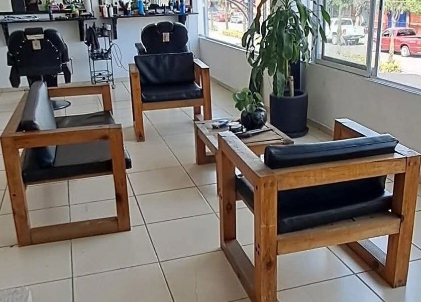 Interior del Hair Cuts Studio en Pedro Escobedo, Querétaro, MX con sillas cómodas y plantas decorativas.