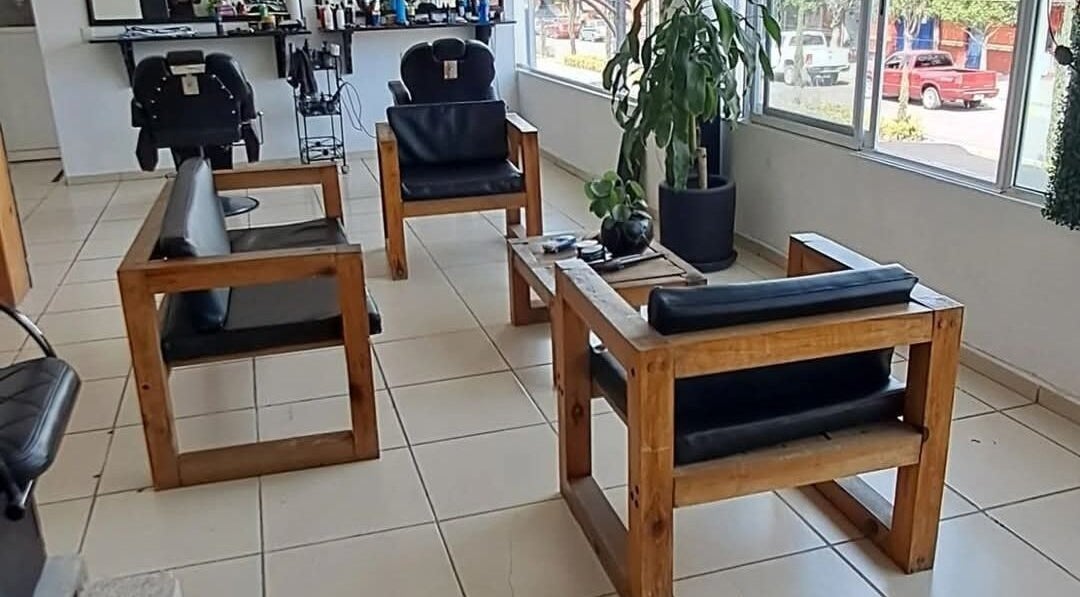 Interior del Hair Cuts Studio en Pedro Escobedo, Querétaro, MX con sillas cómodas y plantas decorativas.