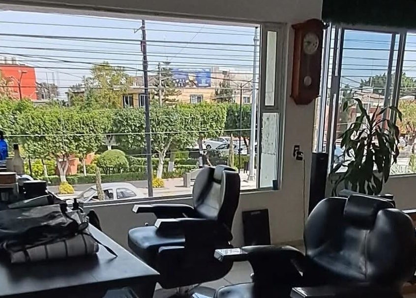 Interior de Hair cuts studio en Pedro Escobedo, Querétaro, MX con sillas de peluquería y vista exterior.