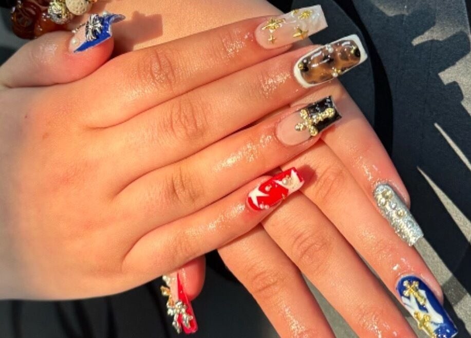 Manucure artistique à LB Esthétique, Rouyn-noranda, Québec, CA, avec des motifs et bijoux brillants.