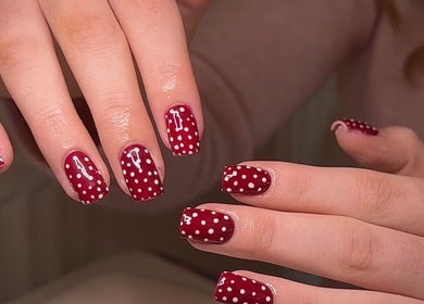 Red polka dot nail art at BySorayah, Birmingham, England, GB showcasing creative manicure design.