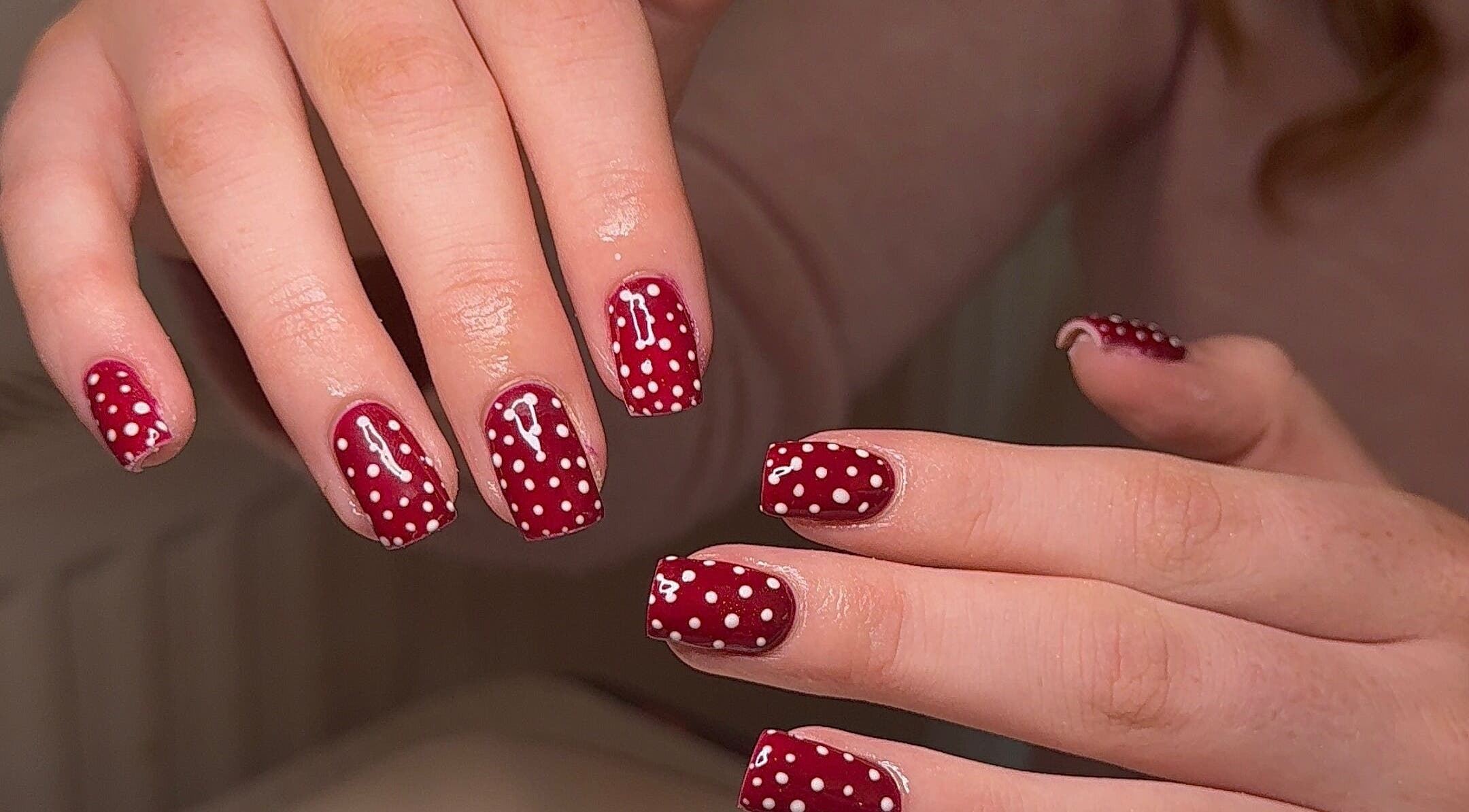 Red polka dot nail art at BySorayah, Birmingham, England, GB showcasing creative manicure design.