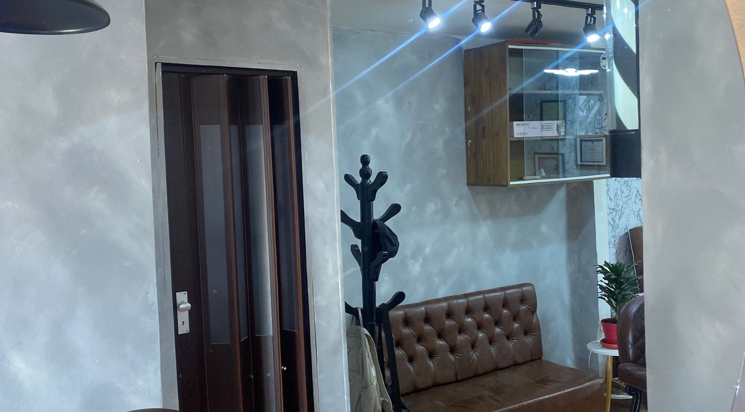 Interior elegante de A U R A - S T U D I O en Soacha, Cundinamarca, CO con sofá marrón y decoraciones modernas.