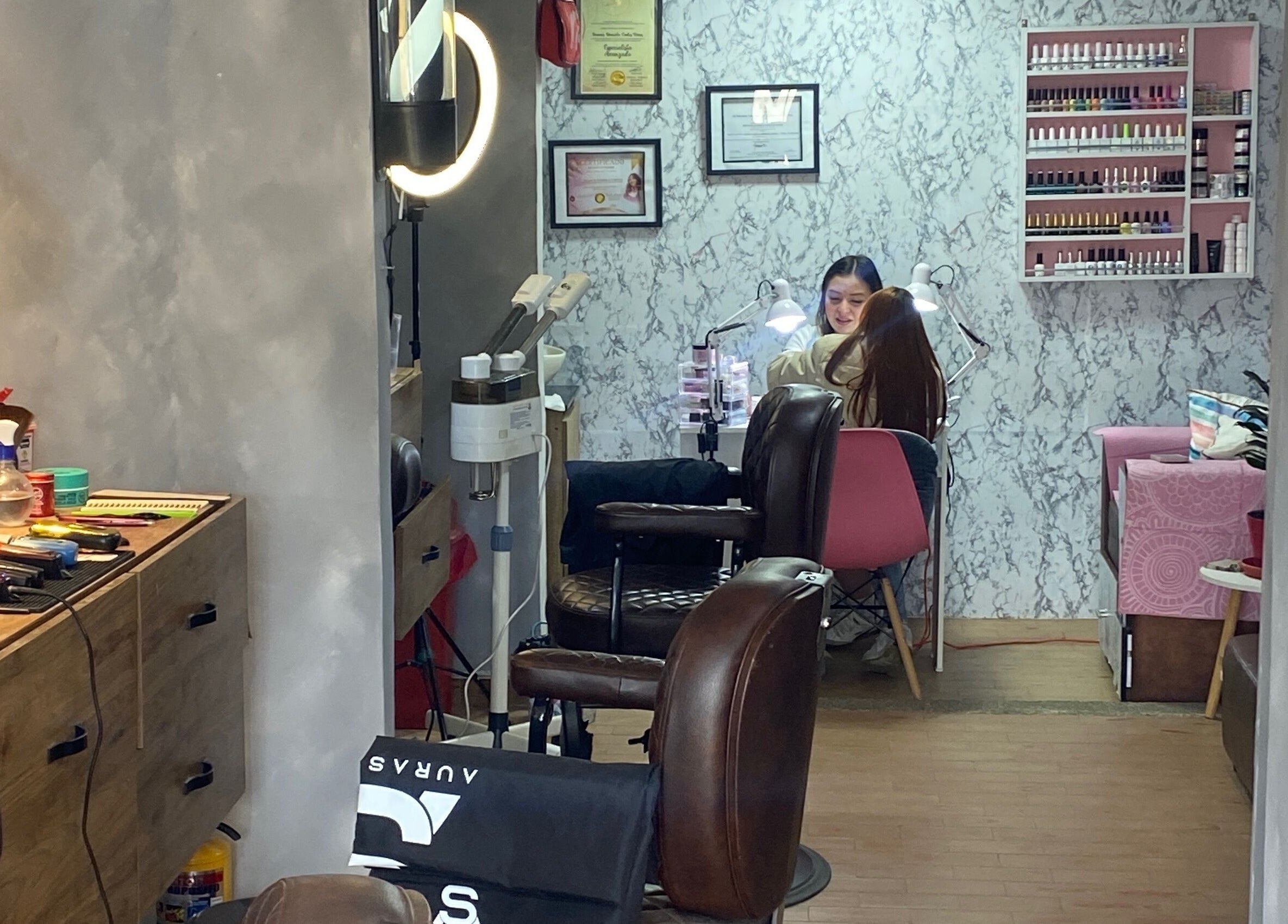 Interior de A U R A - S T U D I O en Soacha, Cundinamarca, CO, con una clienta recibiendo servicio de manicura.
