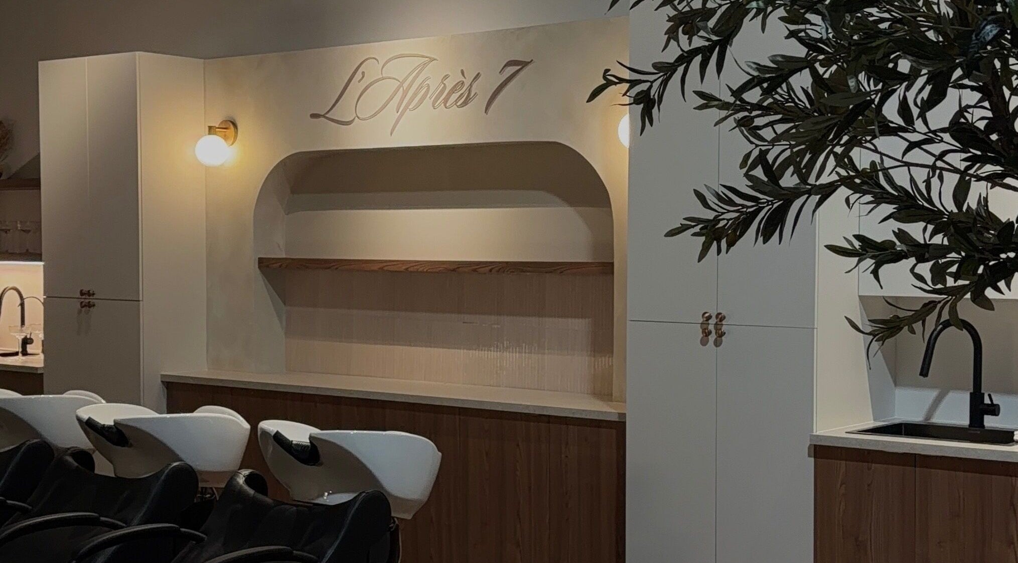 Intérieur élégant de L'Après 7 à Saint-Eustache, Québec, CA avec sièges de coiffure modernes.