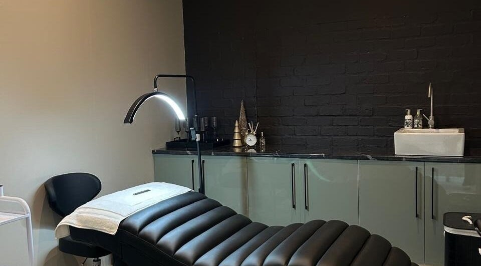 Relaxing treatment room at Ion Beauty and Makeup, Paarl, Western Cape, ZA with a black bed and modern decor.