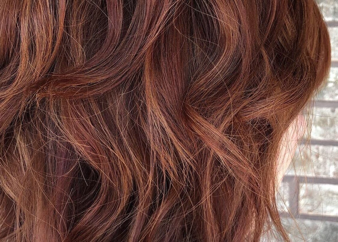 Voluminous copper waves styled at Hair Shack, Bourbon, Missouri, US enhance the beauty of this hairstyle.