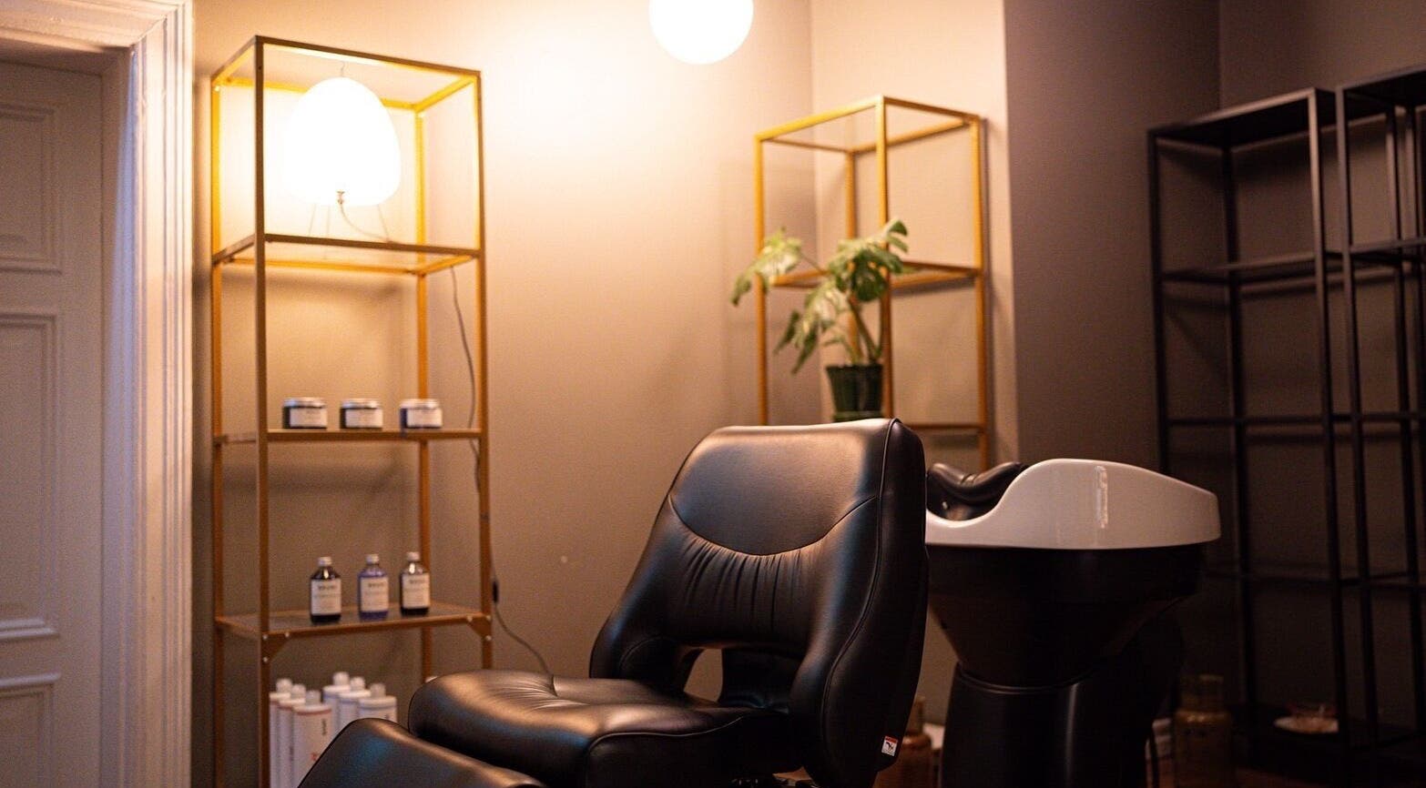 Elegant salon chair at Whyte in Malmö, Skåne Län, SE, surrounded by chic shelves and warm lighting.